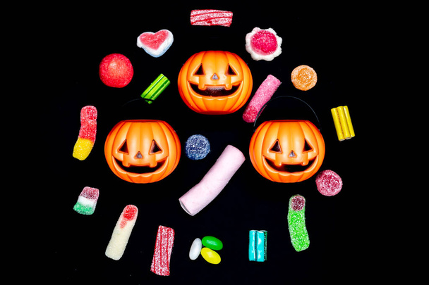 Citrouilles d'Halloween entourées de bonbons et friandises. Fêtes d'Halloween. Jour des Morts. - Photo, image