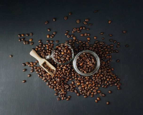 Coffee beans background. Roasted Coffee concept with differents types of coffee, beans and cinnamon sticks on dark black stone background. Top view. Coffee concept. Mock up. Coffee time. Coffee break. - Photo, Image
