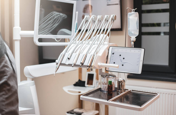 Een tandarts die zijn tandheelkundige apparatuur op een patiënt gebruikt. Tandheelkundige apparatuur. - Foto, afbeelding