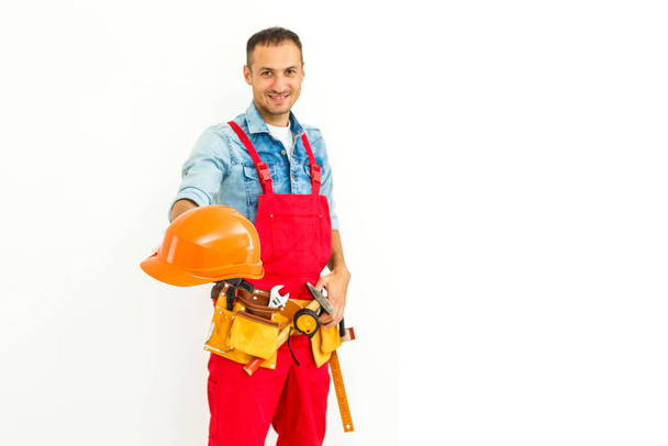 Trabajador de construcción masculino serio con pelo negro corto en uniforme con los brazos cruzados - Aislado - Foto, imagen