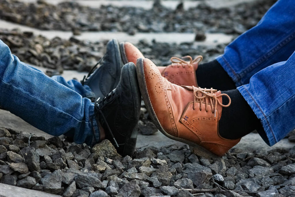 feet father and son cowboy shoes near railway - 写真・画像