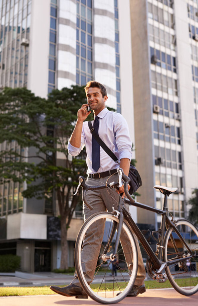 Je serai au bureau dans 10. un homme d'affaires prenant un appel téléphonique pendant qu'il se rend au travail avec son vélo - Photo, image