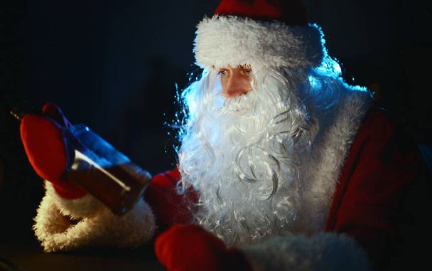 Psychologicznie wyczerpany Święty Mikołaj pije whisky w domu. - Zdjęcie, obraz
