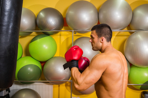 Muscular man in boxing gloves in gym - Foto, imagen