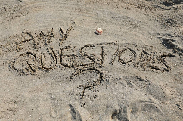 Slova JAKÉ OTÁZKY napsaná na písku pláže - Fotografie, Obrázek