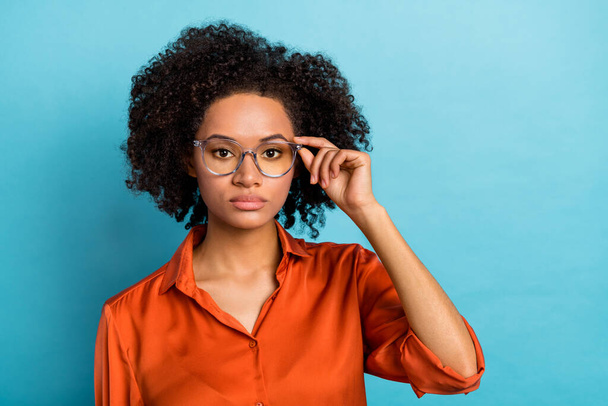 Portrait of attractive serious wavy-haired girl employee touching eyewear specs isolated over bright blue color background. - Valokuva, kuva