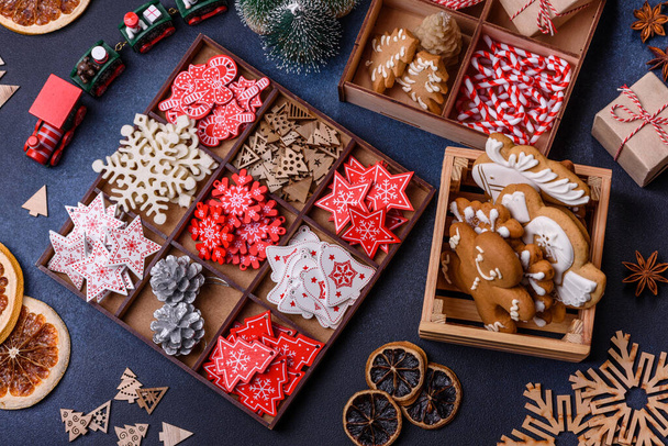 Karácsonyfa fa játékok fehér és piros színekben, mézeskalács és szárított citrom és grapefruit szeletek részeként a karácsonyi kompozíció - Fotó, kép