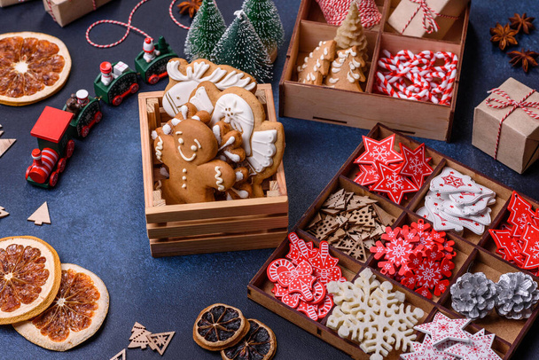 Noel ağacı ahşap oyuncakları beyaz ve kırmızı renklerde, zencefilli ekmek ve kurutulmuş limon ve greyfurt dilimleri Noel kompozisyonu kapsamında - Fotoğraf, Görsel