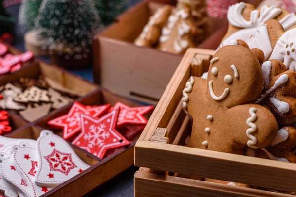 Χριστουγεννιάτικα ξύλινα παιχνίδια σε λευκό και κόκκινο χρώμα, μελόψωμο και φέτες λεμονιού και γκρέιπφρουτ ως μέρος της Χριστουγεννιάτικης σύνθεσης - Φωτογραφία, εικόνα