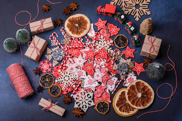 Christmas tree wooden toys in white and red colors, gingerbread and dried lemon and grapefruit slices as part of the Christmas composition - Φωτογραφία, εικόνα