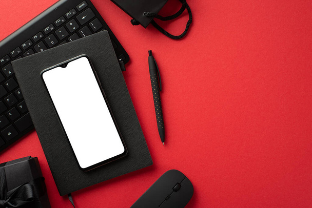 Musta perjantai konsepti. Top view kuva älypuhelin musta suunnittelija kynä tietokone hiiri näppäimistö paperipussi ja lahjapaketti eristetty punainen tausta tyhjä tila - Valokuva, kuva