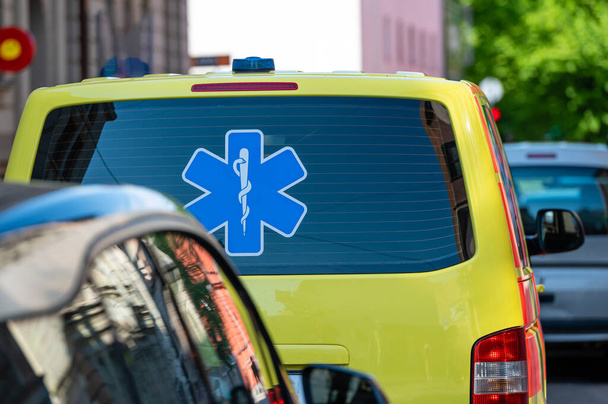 a yellow ambulance emergency car parked on the side of a crowded street, closeup, selective focus - Foto, Bild