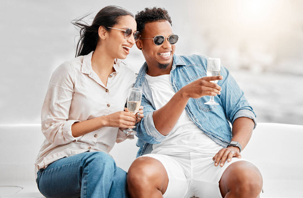 Couple date, champagne celebration and comic conversation at birthday dinner, happy with alcohol and smile for love marriage in the city. Man and woman on terrace with glass of wine in summer. - Foto, Imagem