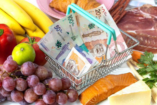 wzrost cen żywności w kolumbijskich sklepach, Koncepcja rosnącej inflacji, owoców, warzyw, mięsa, sera i wewnątrz koszyka zakupów z pieniędzmi z Kolumbii - Zdjęcie, obraz
