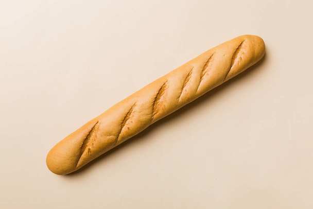 Baguette francese minimalista su sfondo colorato. pane fresco come sfondo, vista dall'alto con spazio per il testo o il design. - Foto, immagini