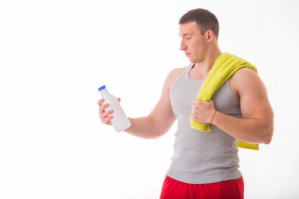 Athletic man holding a bottle of milk - Valokuva, kuva