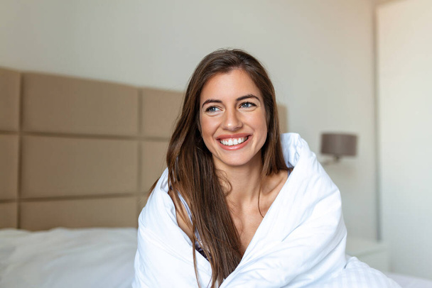 Woman wrapped in a blanket after wake up, entering a day happy and relaxed after good night sleep. Sweet dreams, good morning, new day, weekend, holidays concept - Foto, Imagem