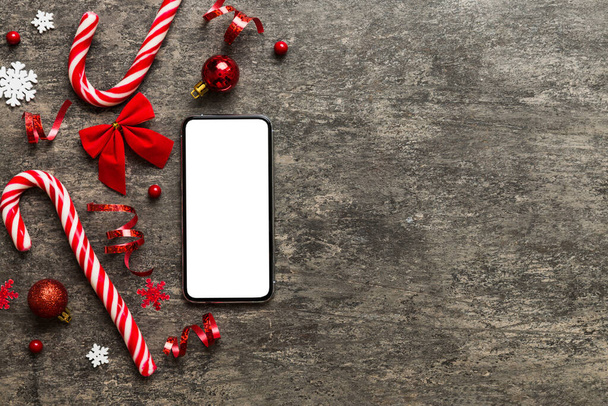 Digital phone mock up with rustic Christmas decorations for app presentation top view with empty space for you design. Christmas online shopping concept. Tablet with copy space on colored background. - Foto, imagen
