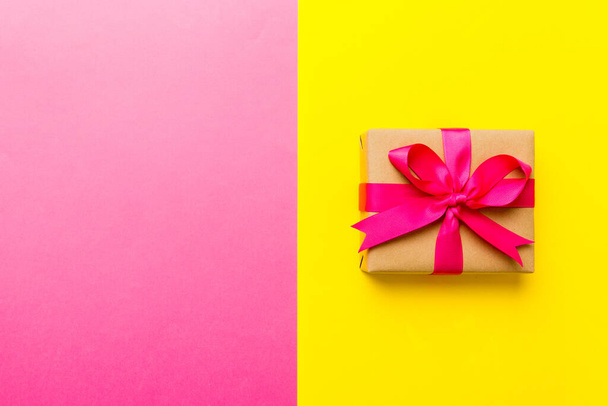 holiday paper present tied pink ribbon bow top view with copy space. Flat lay holiday background. Birthday or christmas present. Christmas gift box concept with copy space. - 写真・画像