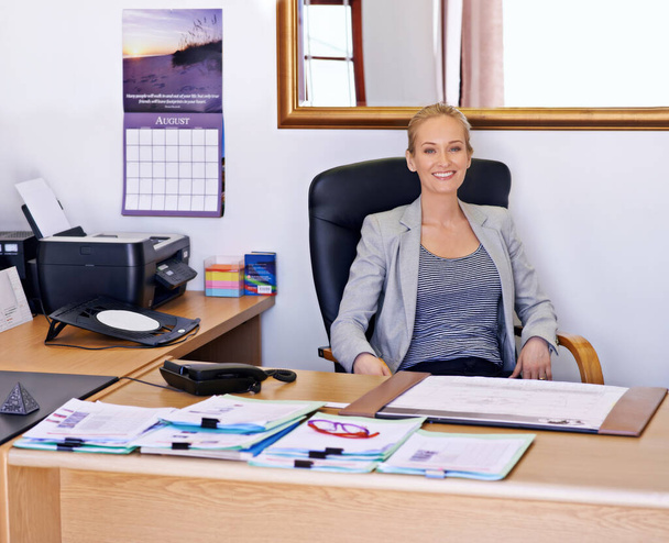 Mijn kantoor is altijd open. een aantrekkelijke jonge vrouw zit aan haar bureau in een kantoor - Foto, afbeelding