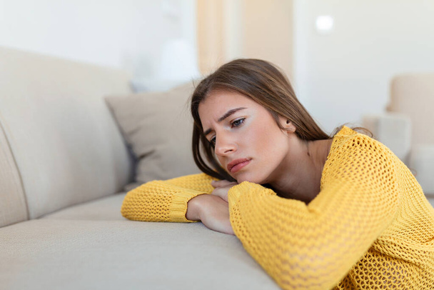Upset woman frustrated by problem with work or relationships, sitting on couch, covered face in hand, feeling despair and anxiety, loneliness, having psychological trouble - Foto, Imagem