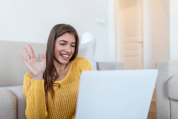 Young woman waving at laptop and talking to her friends via video call, girl student talking by video conference call, female teacher trainer tutoring by webcam, online training, e-coaching concept - Photo, Image