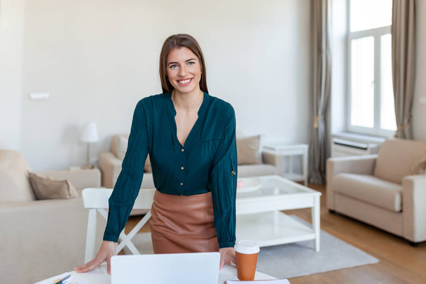 Smiling young female employee stand at desk in office look in distance thinking or visualizing career success. Happy businesswoman plan or dream at workplace. Business vision concept. - Photo, Image