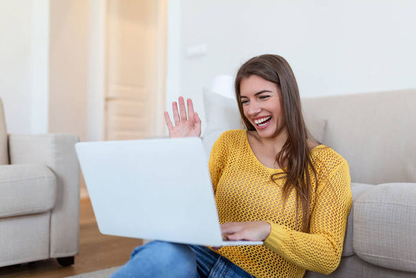 Young woman waving at laptop and talking to her friends via video call, girl student talking by video conference call, female teacher trainer tutoring by webcam, online training, e-coaching concept - Photo, Image
