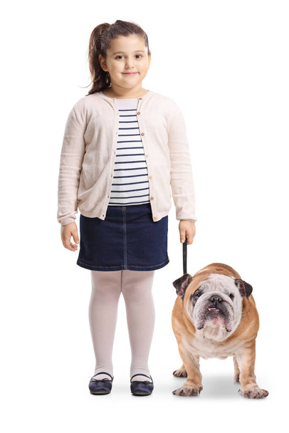 Full length portrait of a little girl with a bulldog smiling at the camera isolated on white background - Valokuva, kuva