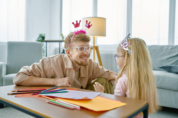 Father and daughter in cute headbands having fun playing together, happy family leisure time at home - Photo, image