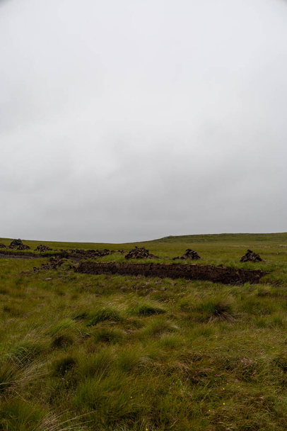 Frisch geschnitten. nasse und feuchte Torfscheiben, die im Sommer in einer schottischen Moorlandschaft auf der Isle of Lewis und Harris, den äußeren Hebirden, trocknen. Lokaler Brennstoff zum Heizen. - Foto, Bild