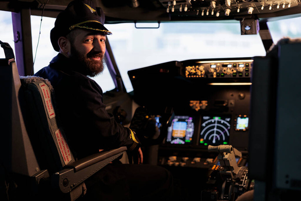 ダッシュボードコマンドボタンとパワーエンジンで飛行機を飛行する準備ができてキャビンに座っている男性キャプテンの肖像画。コントロールパネルスイッチを使用して国際輸送用パイロット飛行ジェット. - 写真・画像