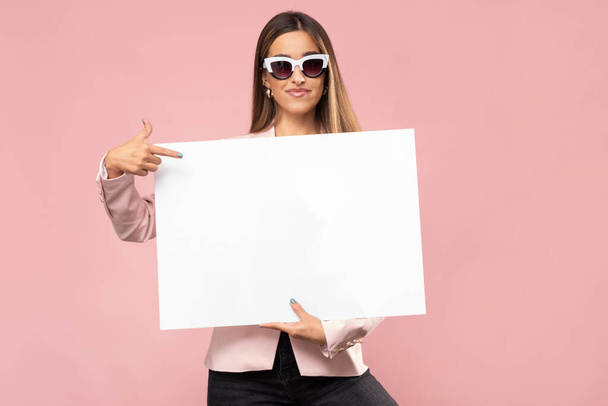 Happy young woman is holding white poster. - Photo, Image