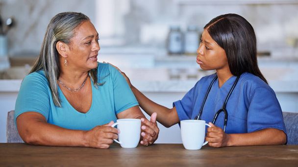Musta nainen, sairaanhoitaja tai iäkäs potilas tukea, puhuminen tai mukavuutta. Lääkärikonsultti, hoitaja tai naislääkäri, joka keskustelee iäkkään naisen kanssa hoitokodissa luottamuksen, neuvonnan tai avun saamiseksi - Valokuva, kuva