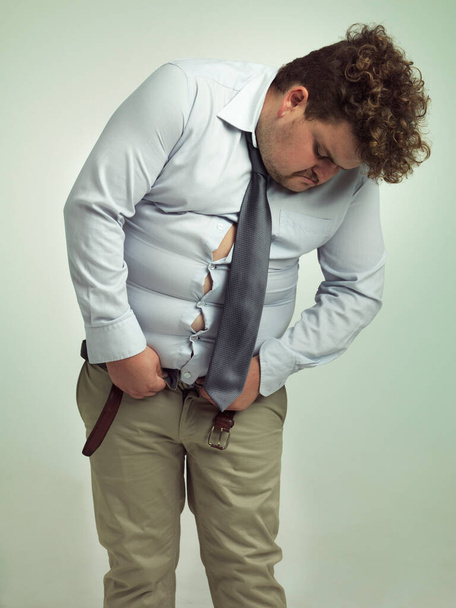 Are these even my pants. an overweight man trying to close his pants - 写真・画像
