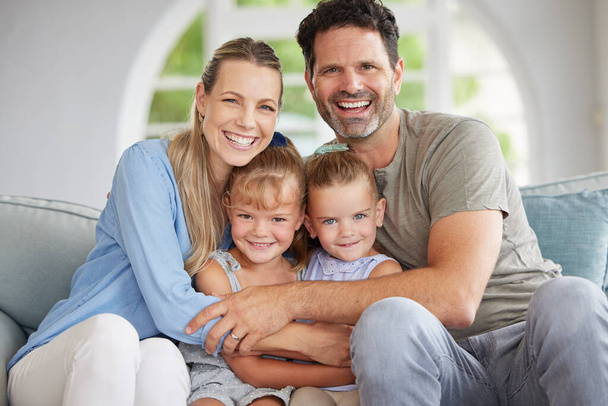 Family portrait, man and woman with children bonding in house living room, home interior and lounge sofa. Happy smile, love couple or mother and father with kids in trust, security and support hug. - Фото, изображение