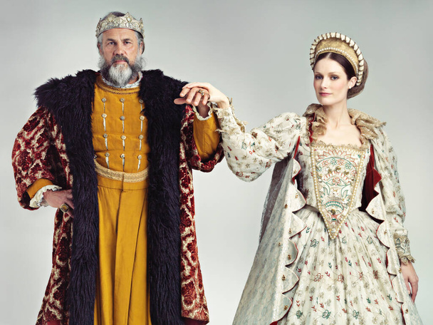 Lord ve Leydi 'yi takdim ediyorum. Bir kral ve kraliçenin stüdyo portresi el ele duruyor. - Fotoğraf, Görsel