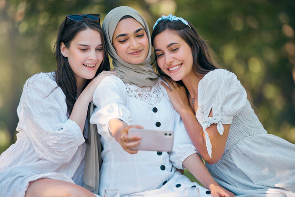 Diversity group of women, friends and selfie in park, garden and outdoor picnic together. Happy, smile and multicultural woman community taking phone photos for social media, fun and summer lifestyle. - Фото, зображення