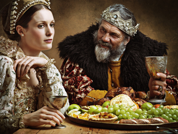 Hes feasting and his goblet is full...again. A bored queen sitting alongside her husband at a banquet - Photo, Image