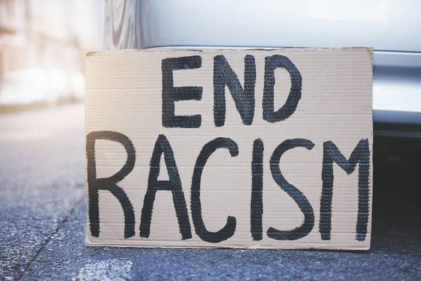 Vessünk véget a rasszizmus plakátjának, írjuk alá és plakátoljuk a tiltakozást az egyenlőség, az emberi jogok és a faji problémák városi utcai hátterében. Karton vagy hirdetőtábla reklám méltányosság, igazságosság és közösségi szabadság. - Fotó, kép