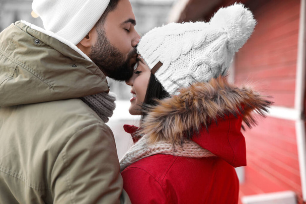 Happy young couple spending time together at winter fair. Christmas celebration - 写真・画像