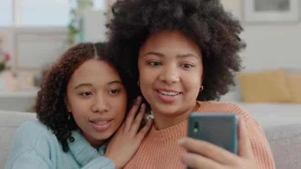 Mutlu, arkadaşlar ve selfie bir kanepede, bir salonda dinlenirken kaynaşırken ve gülerken. Neşeli siyahi kadınlar arkadaşlıklarının tadını çıkarıyorlar ve sosyal medya için eğlenceli bir anın fotoğrafını çekiyorlar.. - Video, Çekim