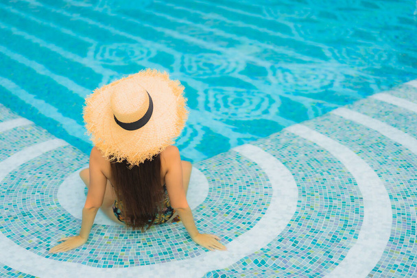 Портрет красива молода азіатка розслабляє посмішку навколо відкритого басейну в готельному курорті у відпустці
 - Фото, зображення