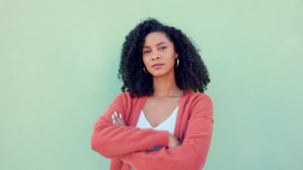 Black woman, confident beauty and young model pose for portrait with afro hair on green background. African girl in orange sweater, fold arms with cool serious face and casual fashion lifestyle. - Footage, Video