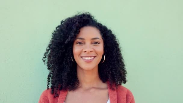 Hymyile, naura ja onnellinen musta nainen vihreällä seinällä. Muotokuva kasvot hauska, nuori ja komedia nuori nainen luonnon afro hiukset, vapaus ja onnea elämään, motivaatio ja hullu vitsi. - Materiaali, video