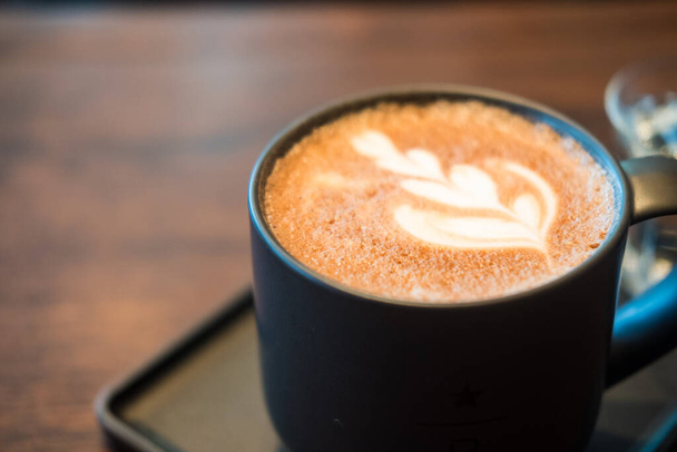 Café moca caliente. Una taza de café con hermoso arte de café con leche. De cerca. - Foto, imagen