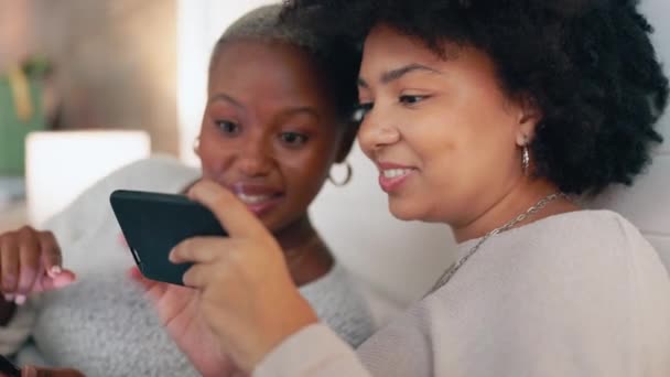 Τηλεφωνική συνομιλία, web social media και φίλοι ευχαριστημένοι με την επικοινωνία στο διαδίκτυο, αναζήτηση σε mobile app και μιλώντας με την τεχνολογία στον καναπέ. Μαύρες γυναίκες με χαμόγελο για smartphone στο σπίτι. - Πλάνα, βίντεο