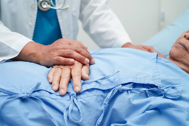 Dokter hand in hand Aziatische bejaarde vrouw patiënt, hulp en zorg in het ziekenhuis. - Foto, afbeelding