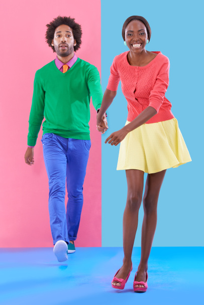 Oh, hes coming with me. Studio shot of a young couple standing against a colourful background - Fotó, kép