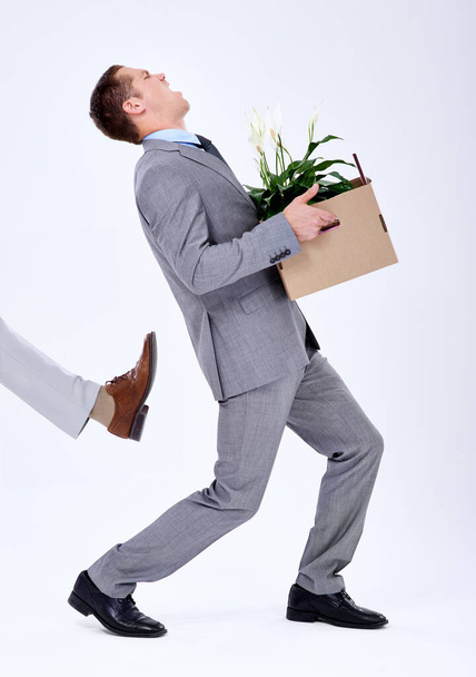 Dándole la bota. un joven hombre de negocios siendo expulsado de su trabajo - Foto, Imagen